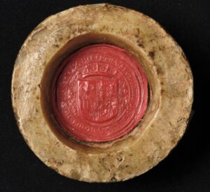 Pieczęć królowej Bony Sforzy. W&nbsp;polach pierwszym i&nbsp;czwartym znajdują się odpowiedniogodła Polski i&nbsp;Litwy, a&nbsp;w&nbsp;polach drugim i&nbsp;trzecim – zespoły godeł dynastycznych królowej: w&nbsp;polu drugim herb Sforzów – skwadrowane orzeł mediolański i&nbsp;wąż Viscontich; w&nbsp;polu trzecim – herb królestwa Neapolu, czyli aragońskie pręgi skwadrowane z&nbsp;umieszczonymi w&nbsp;polu trójdzielnym w&nbsp;słup godłami dynastycznymi Andegawenów neapolitańskich: pasami, liliami i&nbsp;Krzyżem Jerozolimskim. Tarcza otoczona motywem roślinnym. Otok ujęty w&nbsp;sznury perełek z&nbsp;napisem kapitalnym, renesansowym: BONA SFOR[ZA] ARAG[ONA] D[EI] G[RATIA] REGINA POLONIE MAG[NA] DVX LITVANIE Pieczęć okrągła o&nbsp;średnicy 4,1 cm, w&nbsp;miseczce. Odcisk w&nbsp;czerwonym wosku, fragmenty pasków pergaminowych. ANK, Zbiór luźnych pieczęci, sygn. 29/1597/32 